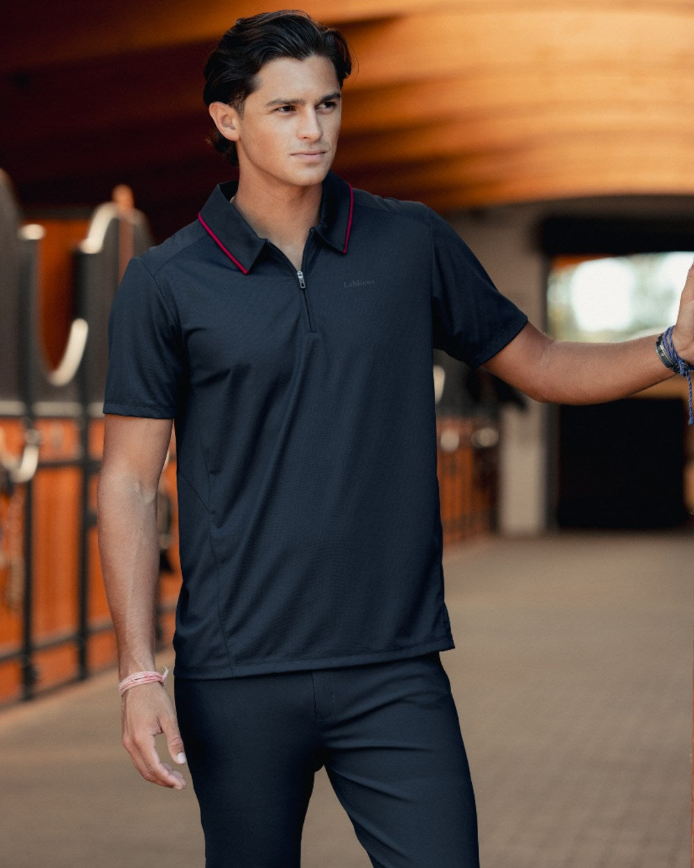 Black coloured LeMieux Mens Performance Polo T-Shirt on outdoor background