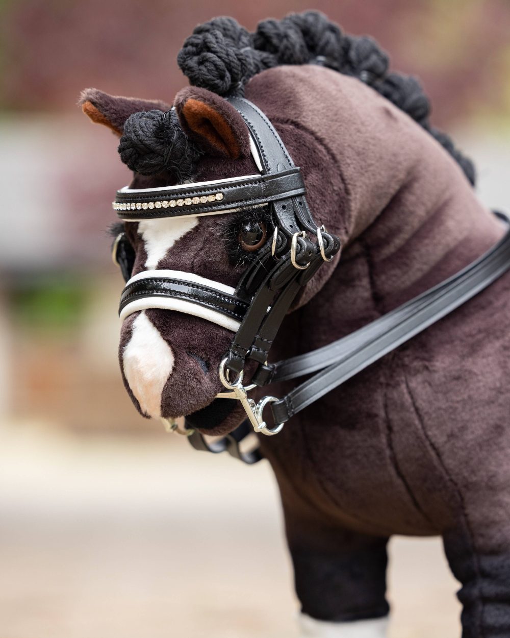 Black coloured LeMieux Toy Pony Double Bridle Black on blurry background
