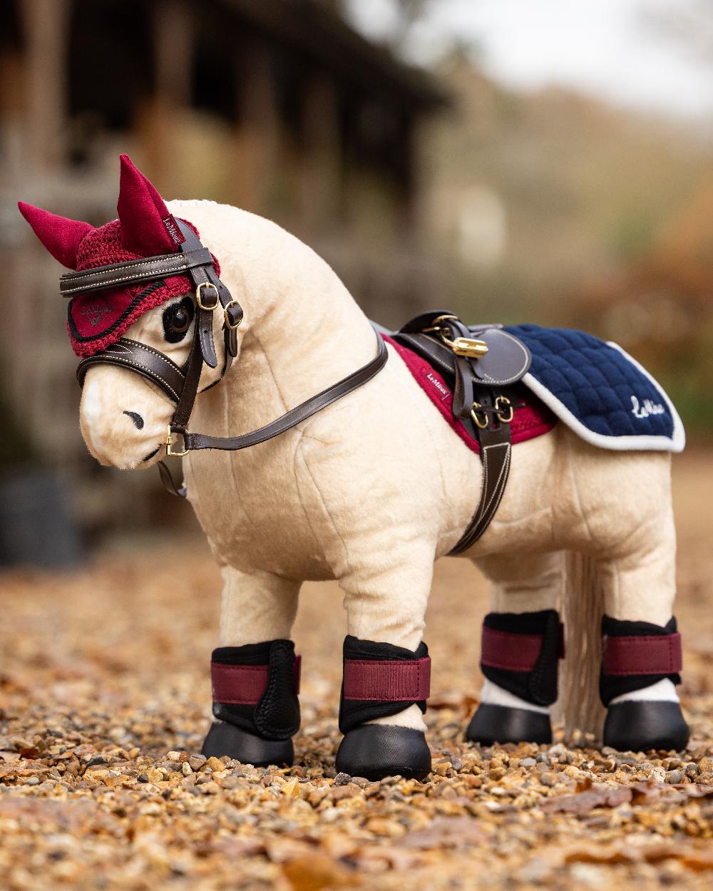 Ember coloured LeMieux Toy Pony Fly Hood on blurry background