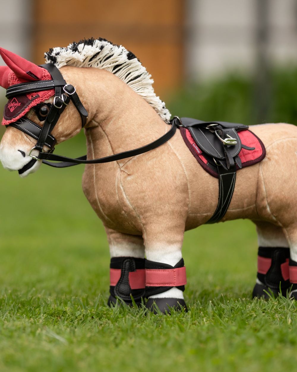 Cranberry Coloured LeMieux Toy Pony Pad On A Grassy Background