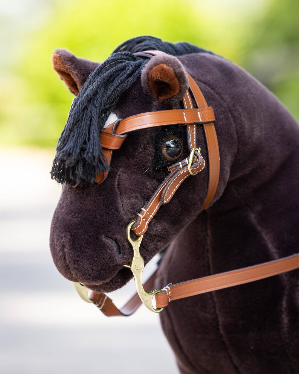Tan coloured LeMieux Toy Pony Western Bridle on blurry background