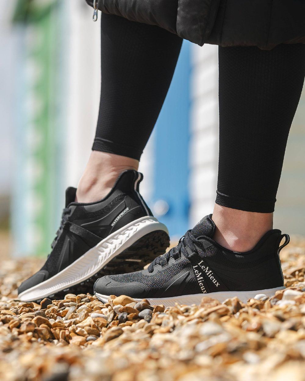 Black coloured LeMieux Trax Waterproof Trainers on blurry background