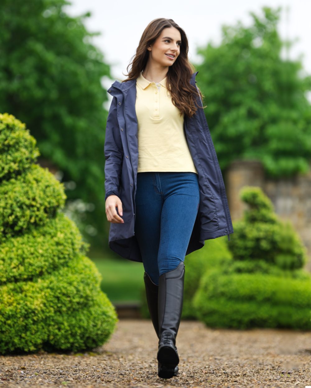 Dusk Blue coloured LeMieux Womens Grace Long Rain Jacket on backyard background