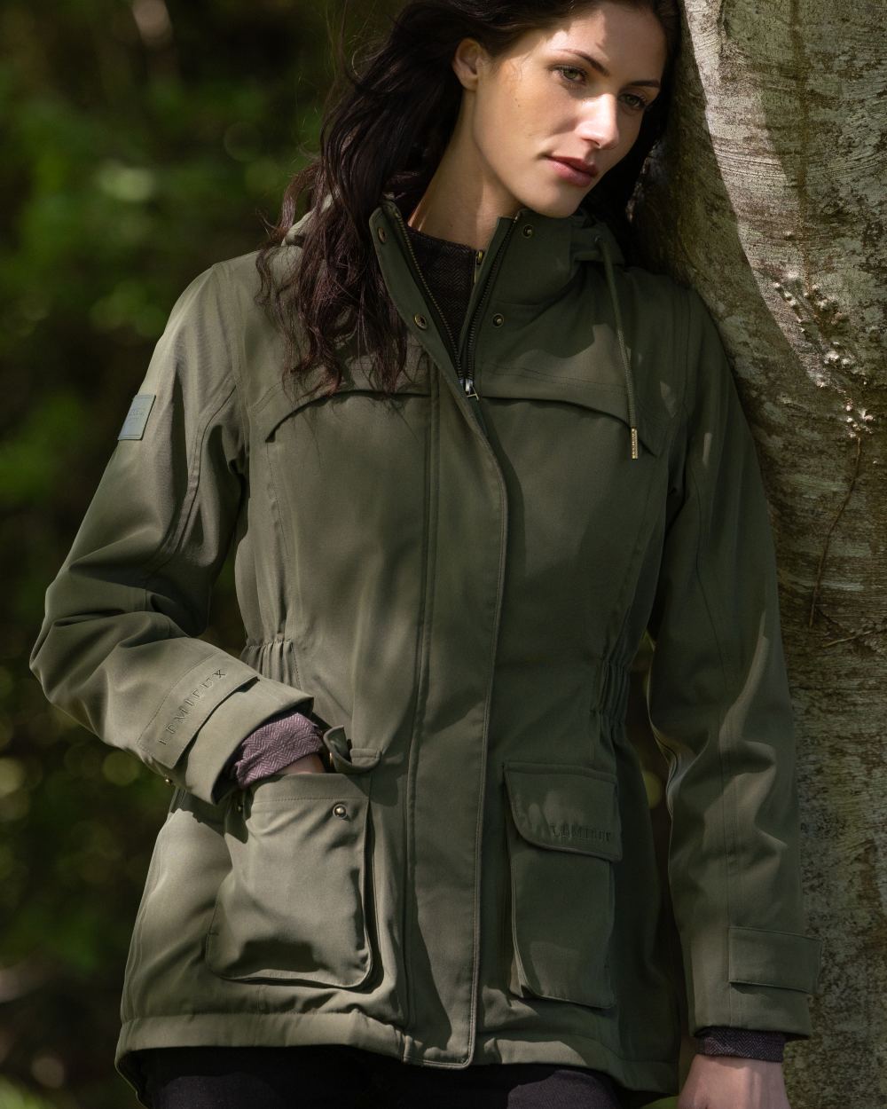 Olive coloured LeMieux Womens Heritage Beatrice Waterproof Coat on outdoor background