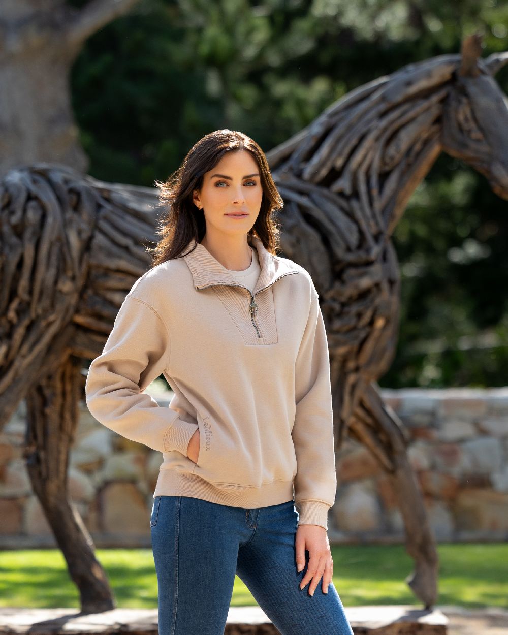 Almond coloured LeMieux Womens Keira Quarter Neck Sweatshirt on backyard background