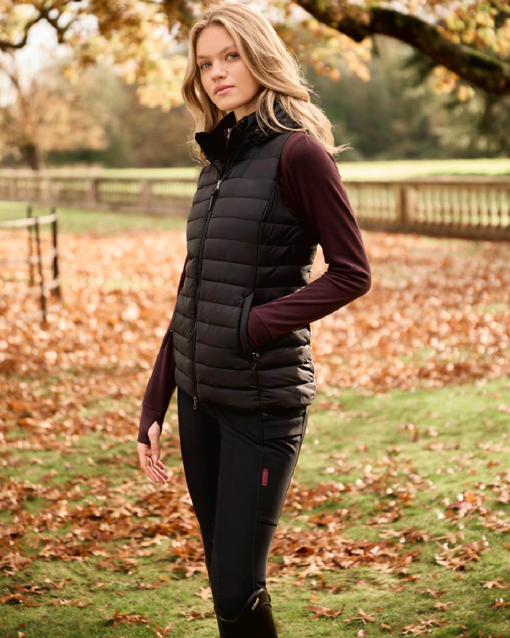 Black coloured LeMieux Womens Rose Hooded Puffer Gilet on outdoor background