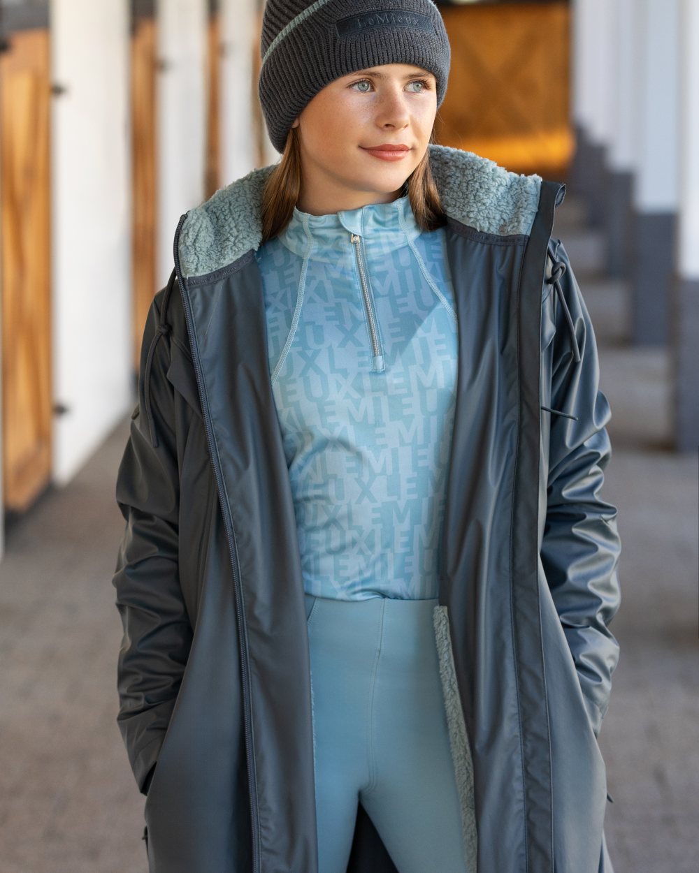 Petrol coloured LeMieux Young Rider All Elements Coat on blurry background