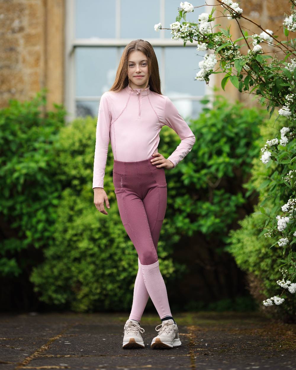 Blossom coloured LeMieux Young Rider Base Layer on backyard background