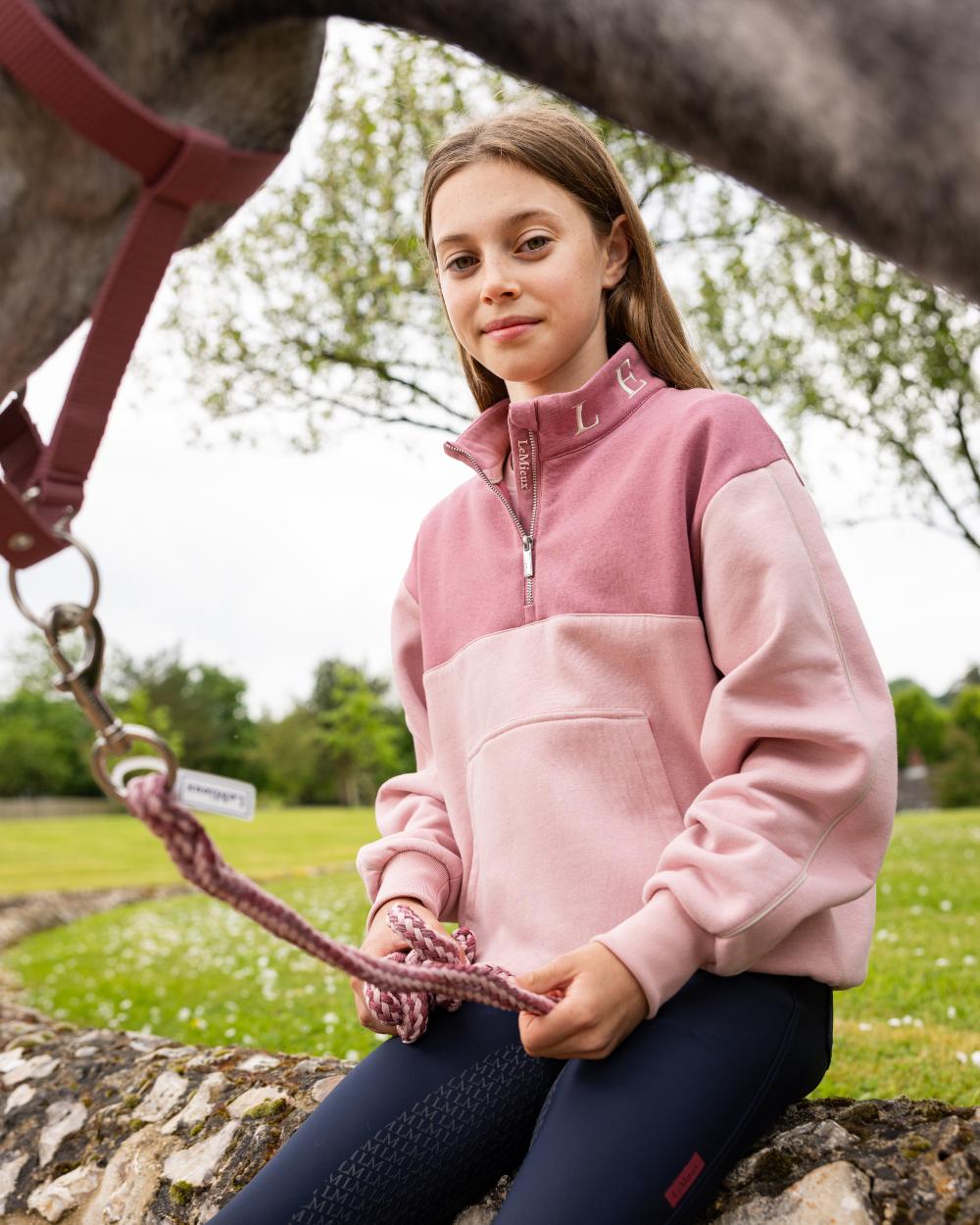 Blossom coloured LeMieux Young Rider Kate Quarter Zip Sweater on lawn background