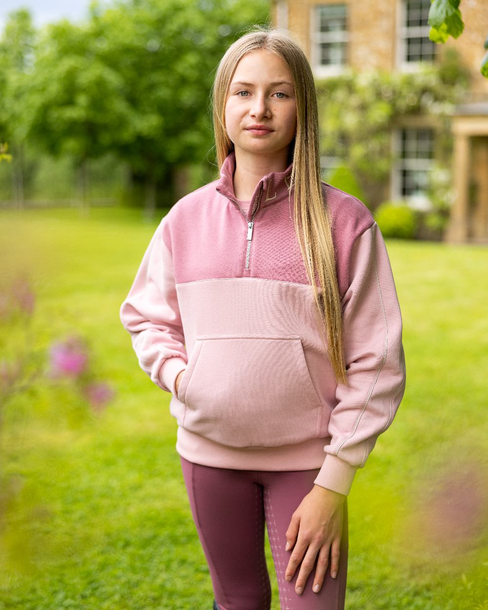 Blossom coloured LeMieux Young Rider Kate Quarter Zip Sweater on backyard background