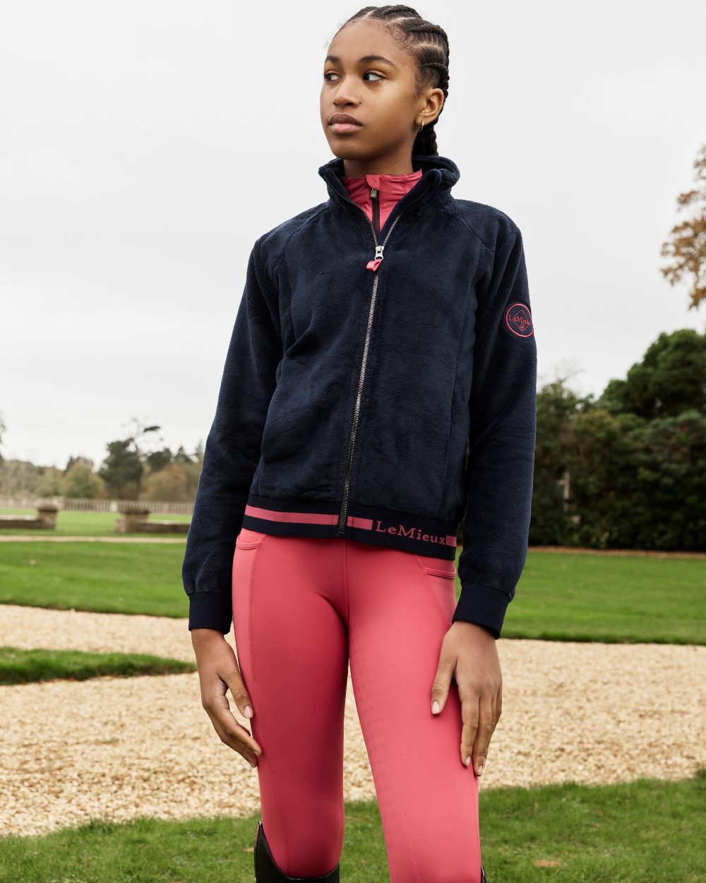 Navy Coloured LeMieux Young Rider Libby Fleece Jacket On A Grassy Background