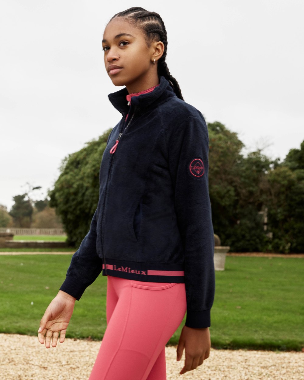 Navy Coloured LeMieux Young Rider Libby Fleece Jacket On A Grassy Background