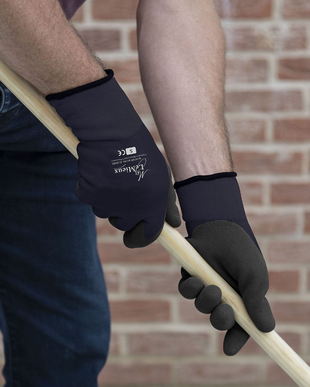 Navy coloured LeMieux Thermal Work Gloves on brick background