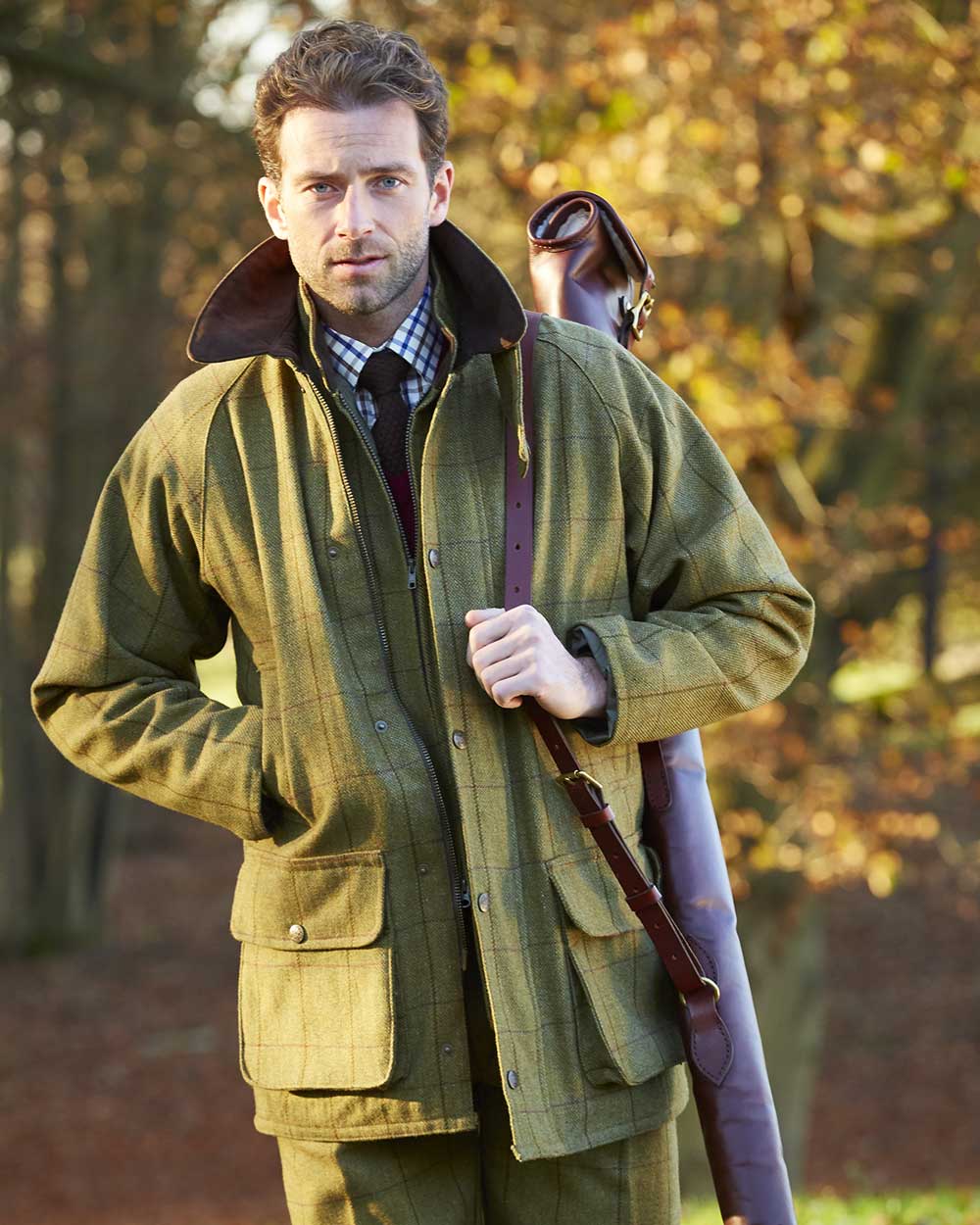 Lichen coloured Alan Paine Rutland Waterproof Tweed Shooting Coat on forest background