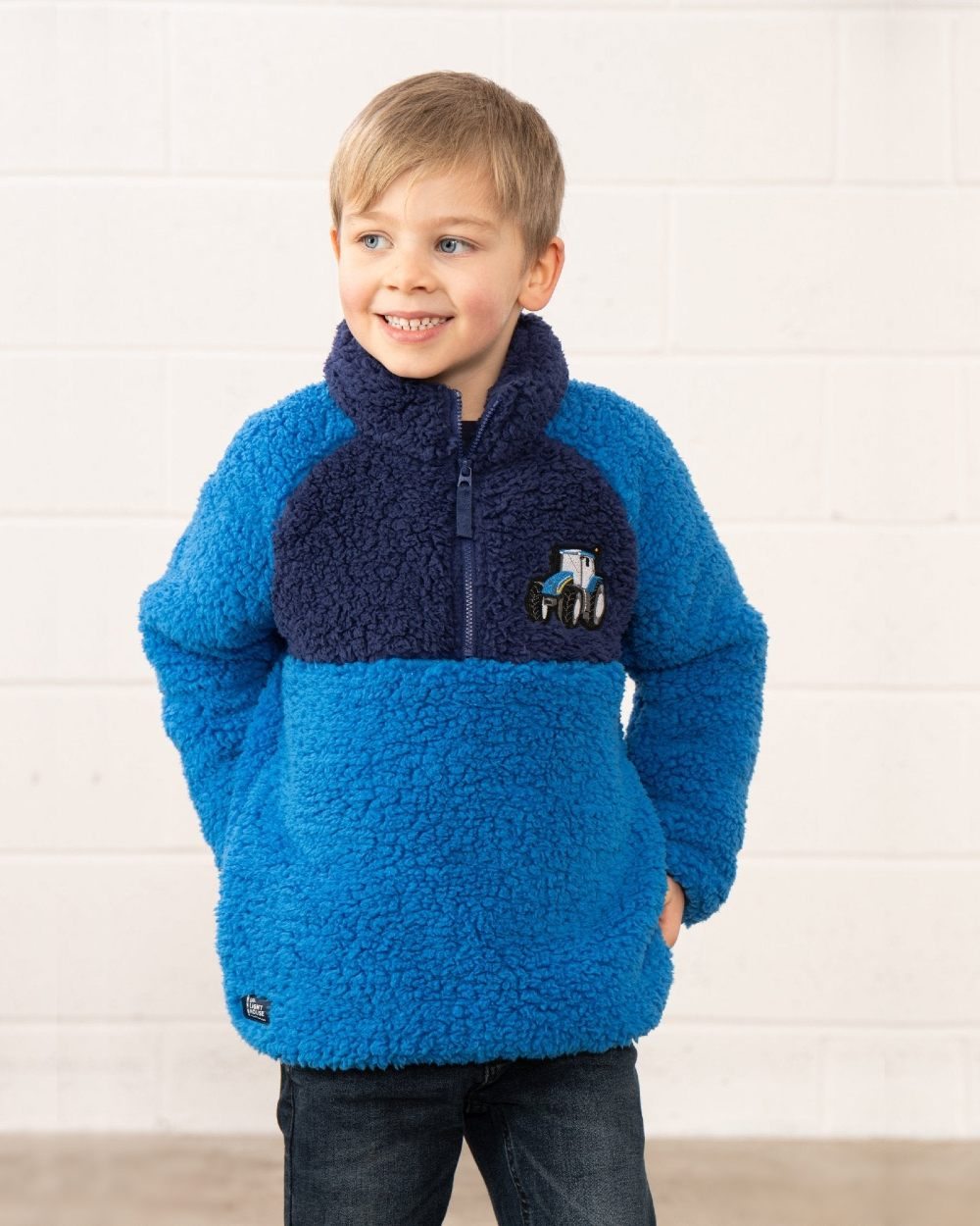 Blue Tractor coloured Lighthouse Childrens Caden Fleece on wall background