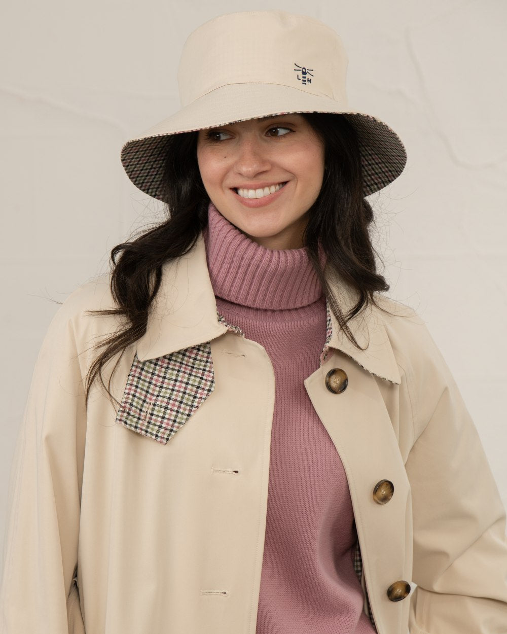 Stone coloured Lighthouse Edie Reversible Rain Hat on wall background