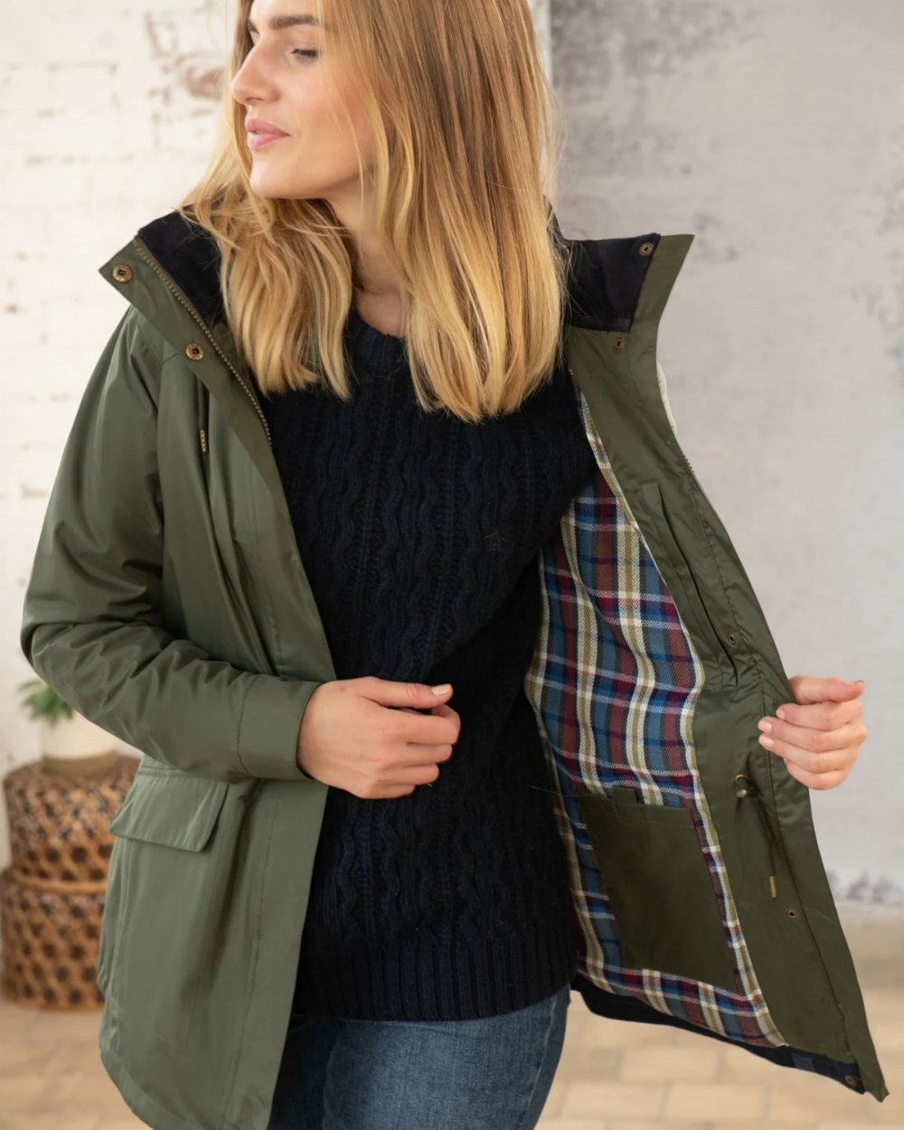 Forest coloured Lighthouse Kendal Waterproof Coat on wall background