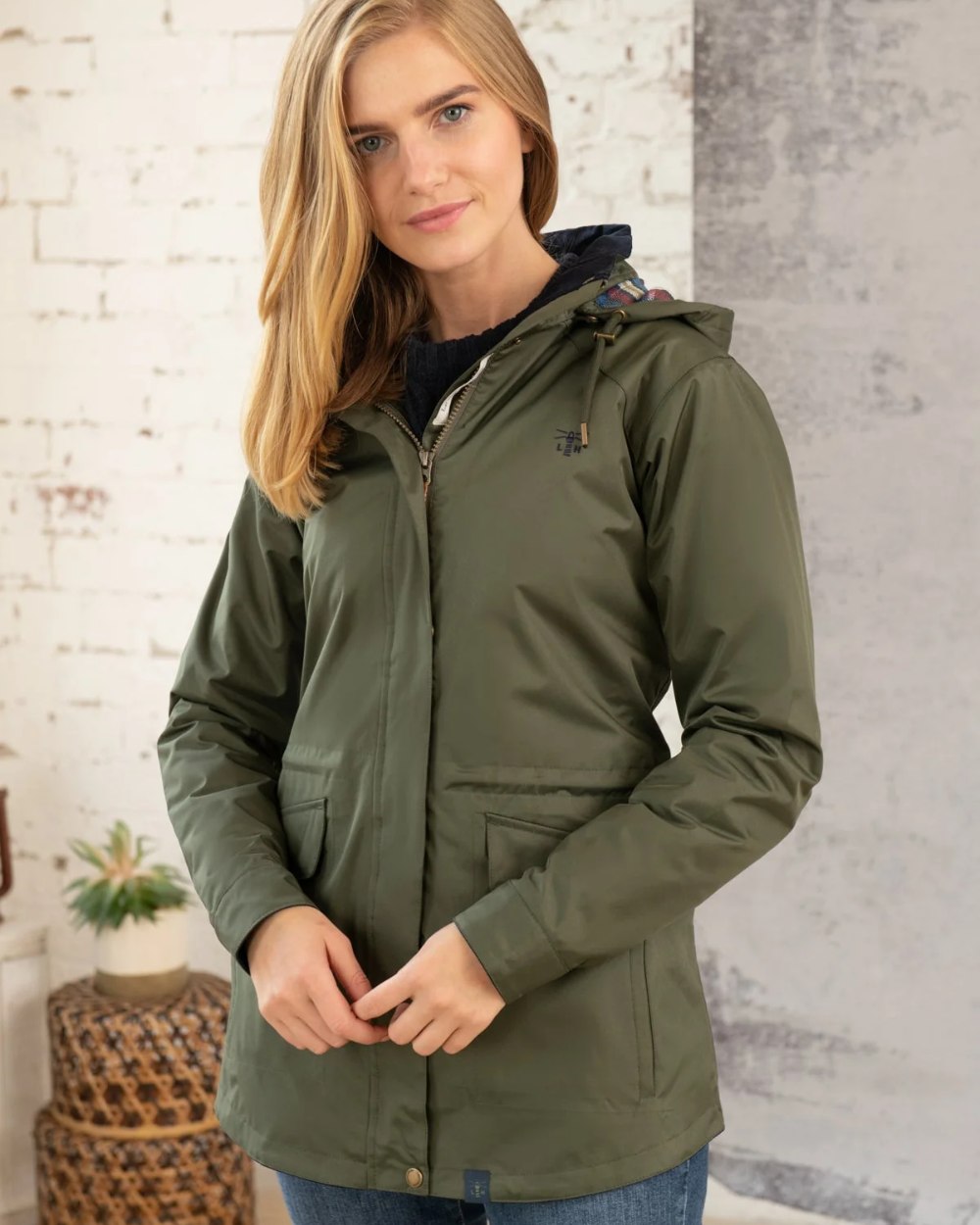 Forest coloured Lighthouse Kendal Waterproof Coat on wall background