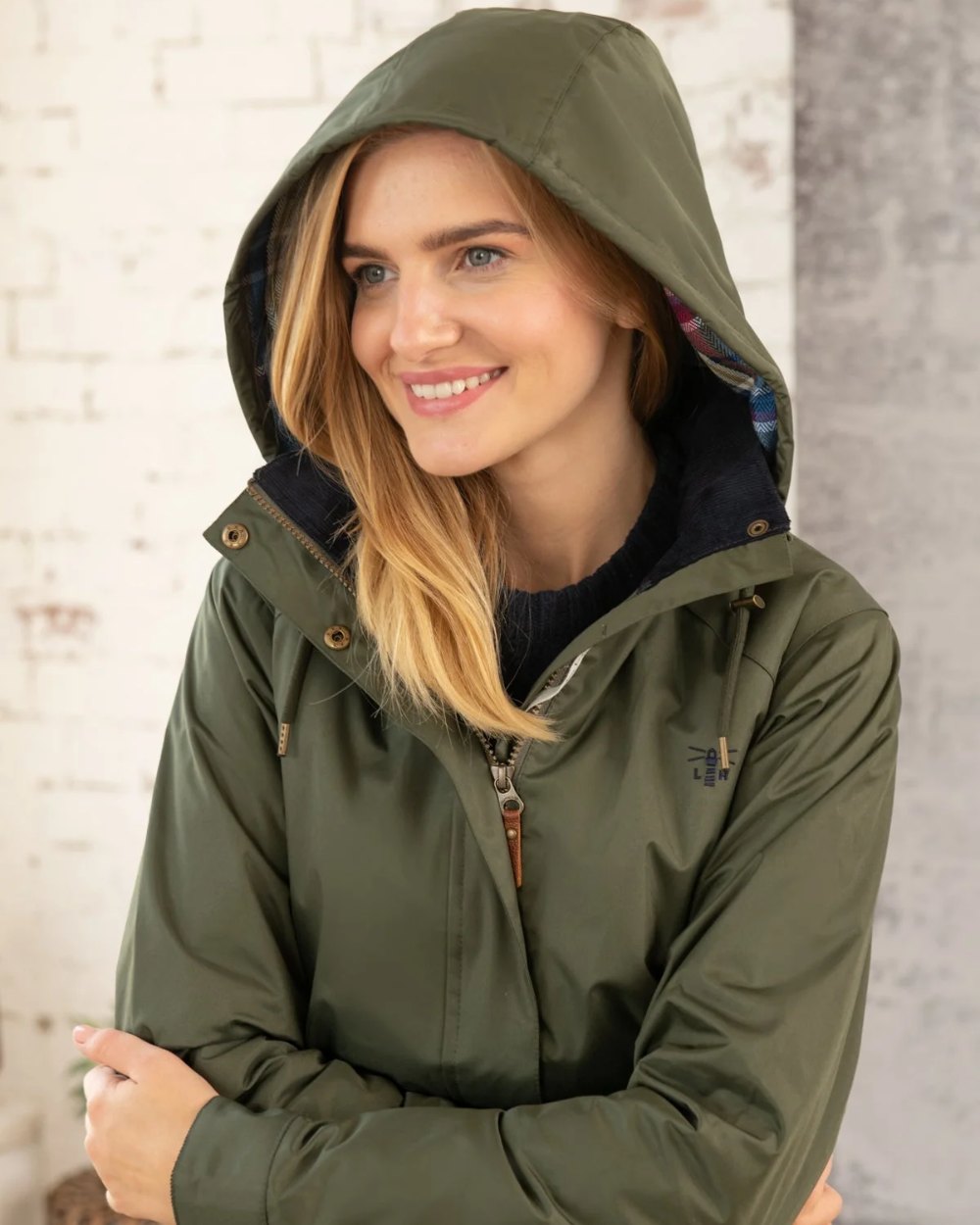 Forest coloured Lighthouse Kendal Waterproof Coat on wall background
