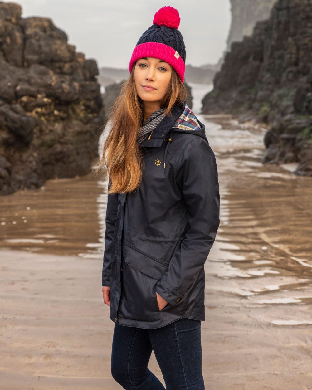 Nightshade coloured Lighthouse Kendal Waterproof Coat on beach background