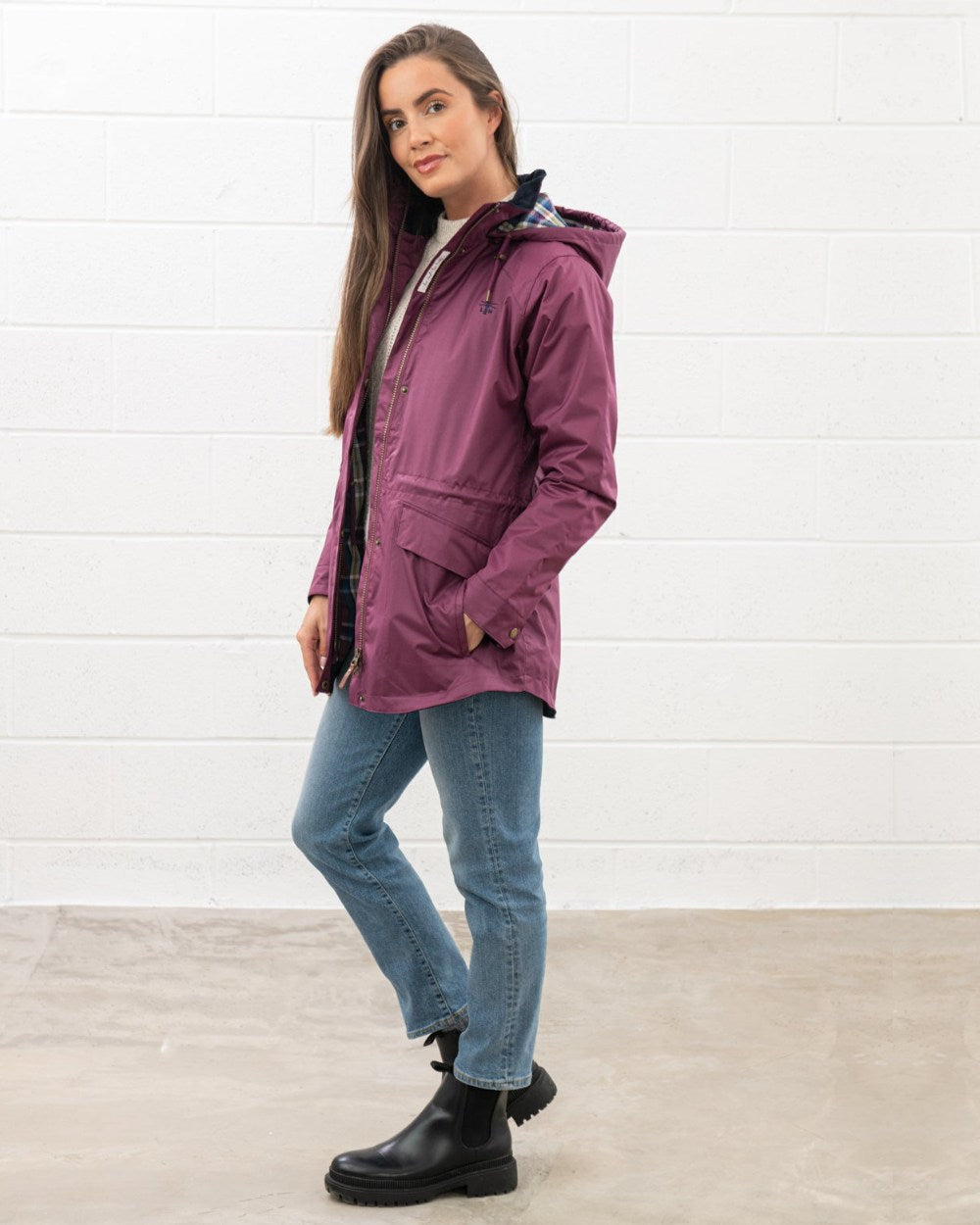 Plum coloured Lighthouse Kendal Waterproof Coat on wall background