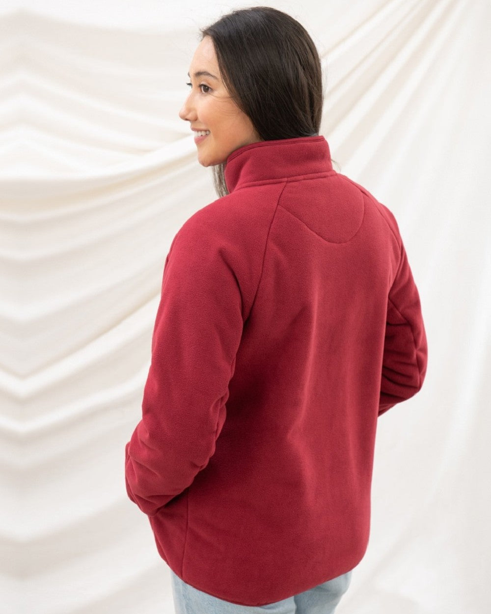 Maroon coloured Lighthouse Ladies Avon Waterproof Fleece on curtain background
