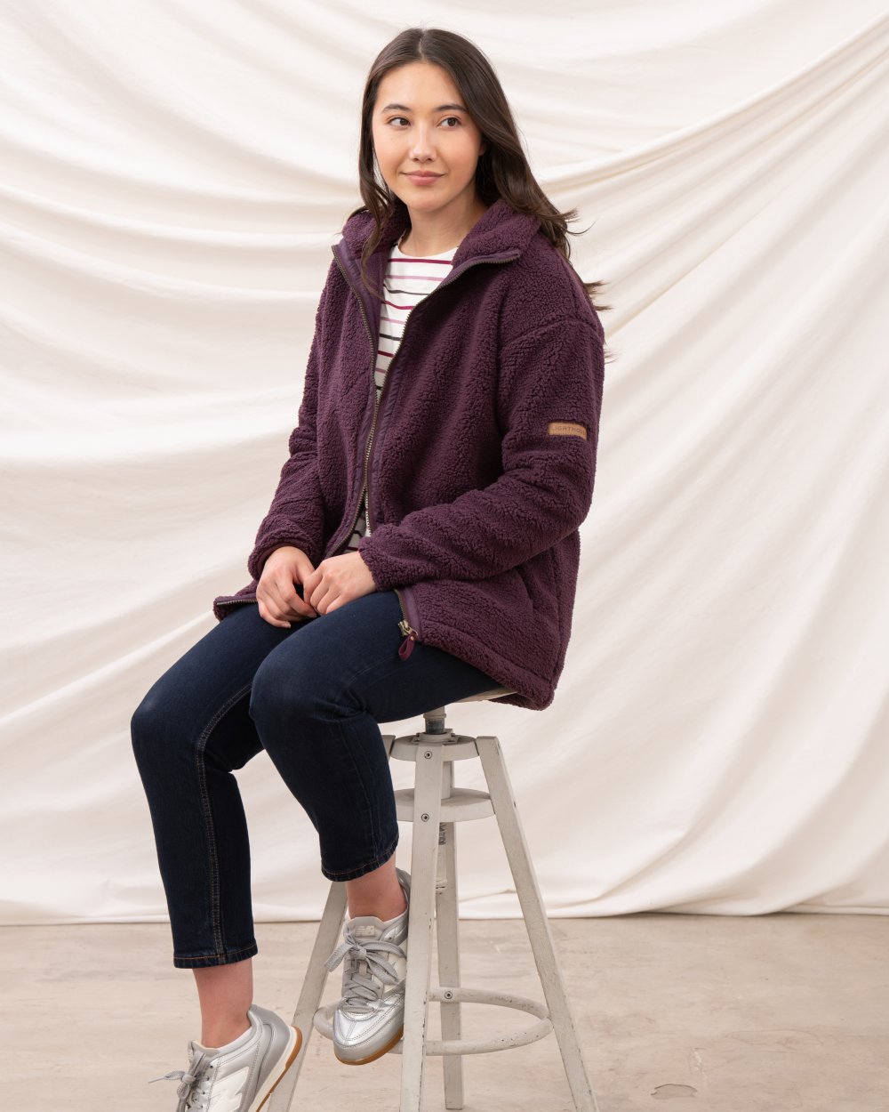 Cranberry coloured Lighthouse Ladies Cobh Full Zip Fleece Jacket on curtain background