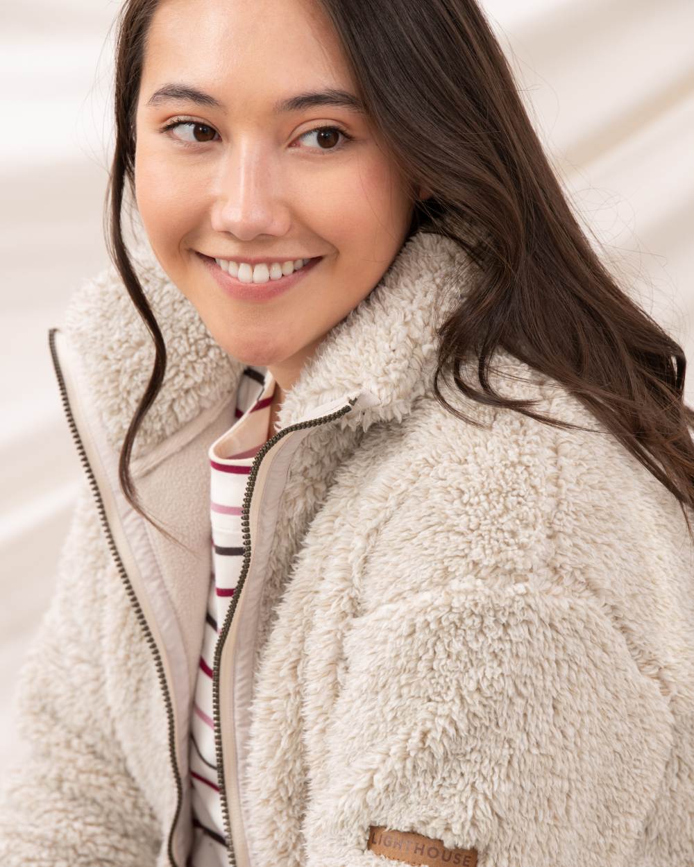 Irish Cream coloured Lighthouse Ladies Cobh Full Zip Fleece Jacket on curtain background