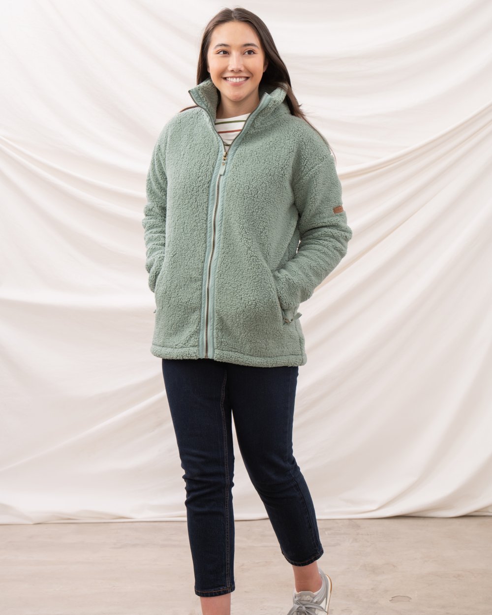 Sage coloured Lighthouse Ladies Cobh Full Zip Fleece Jacket on curtain background