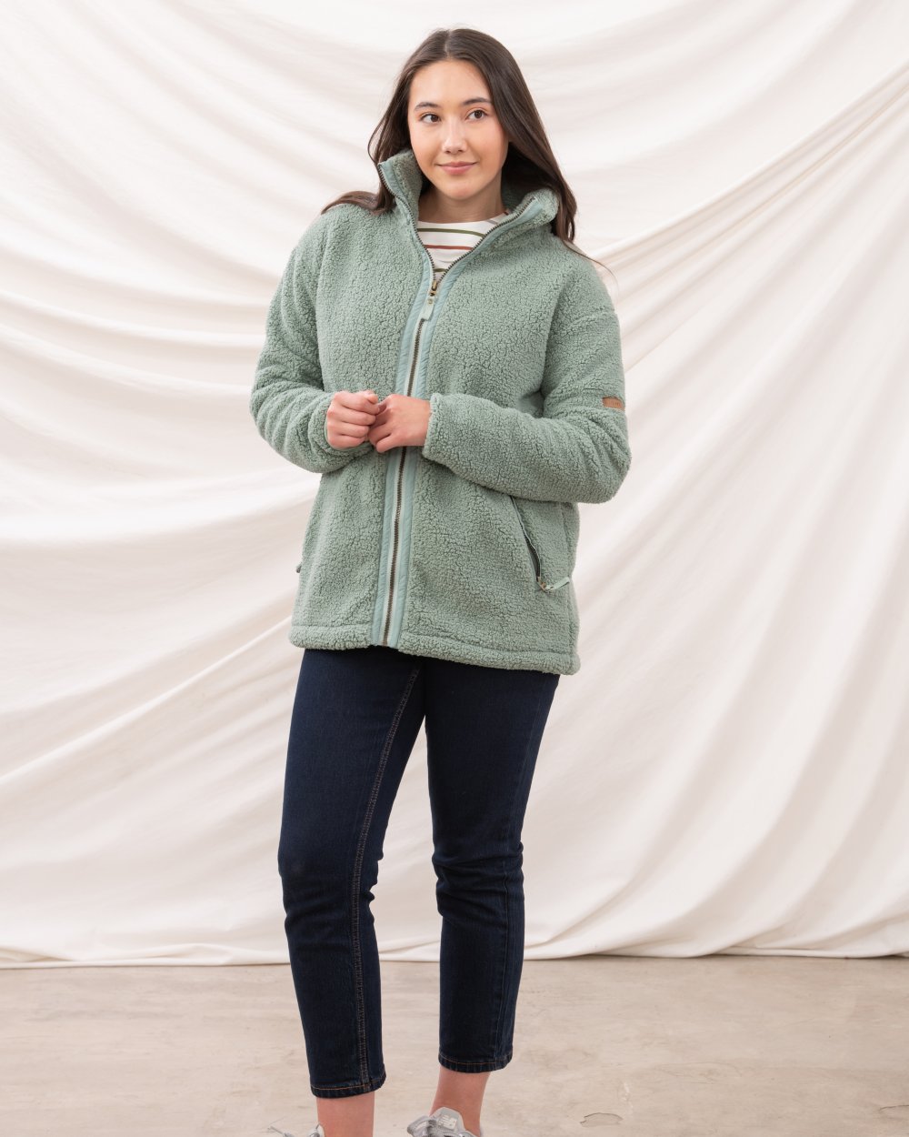 Sage coloured Lighthouse Ladies Cobh Full Zip Fleece Jacket on curtain background