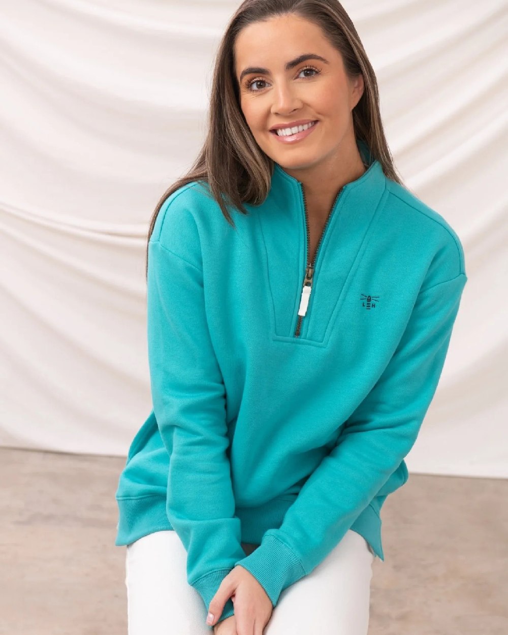 Soft Teal coloured Lighthouse Ladies Coral Jersey on curtain background