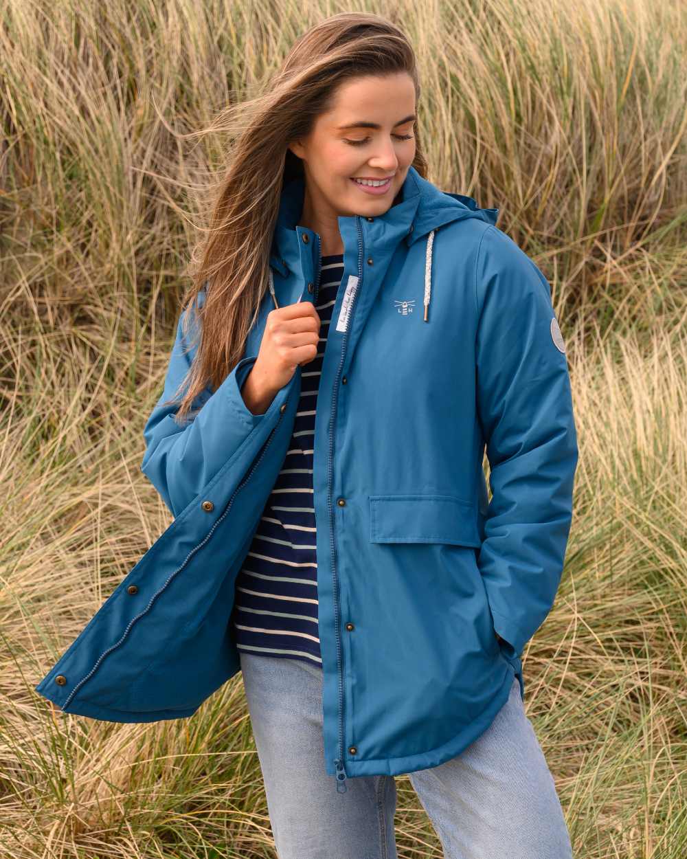 Teal coloured Lighthouse Ladies Tess Coat on grassy background