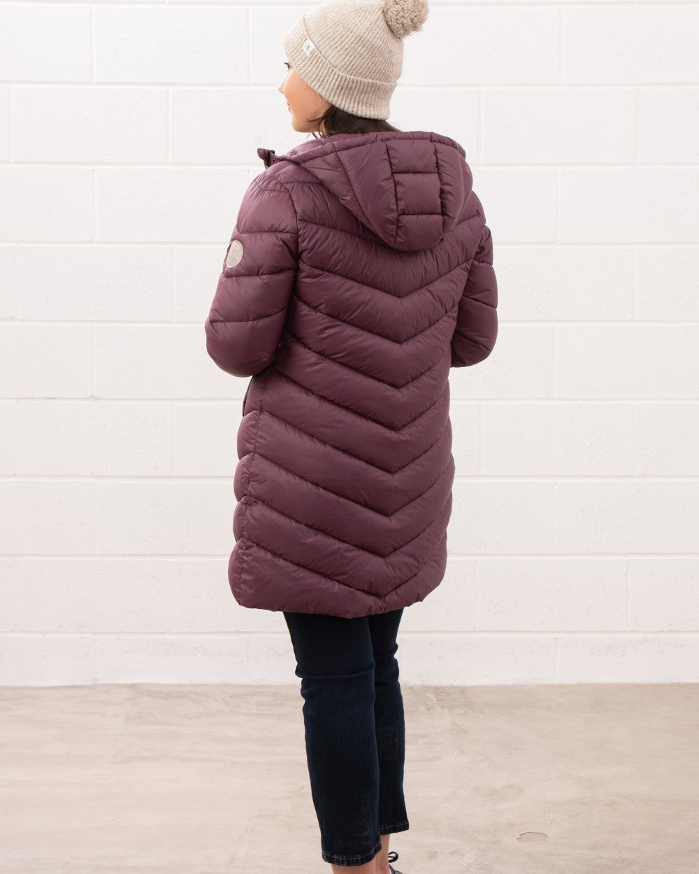 Cranberry coloured Lighthouse Laurel Ladies Coat on wall background