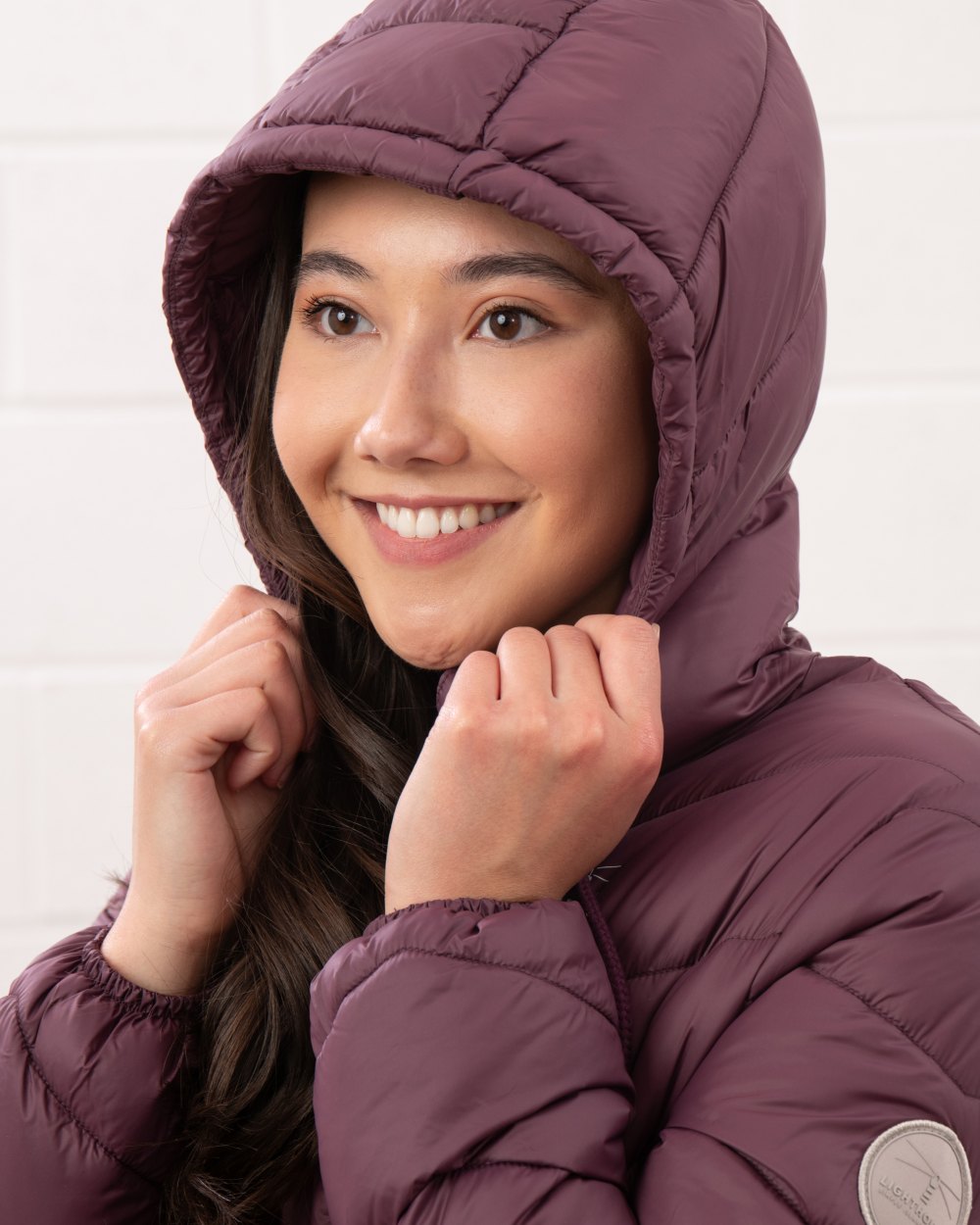 Cranberry coloured Lighthouse Laurel Ladies Coat on wall background