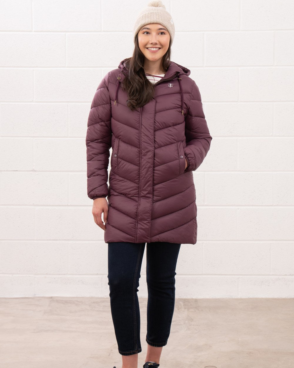 Cranberry coloured Lighthouse Laurel Ladies Coat on wall background