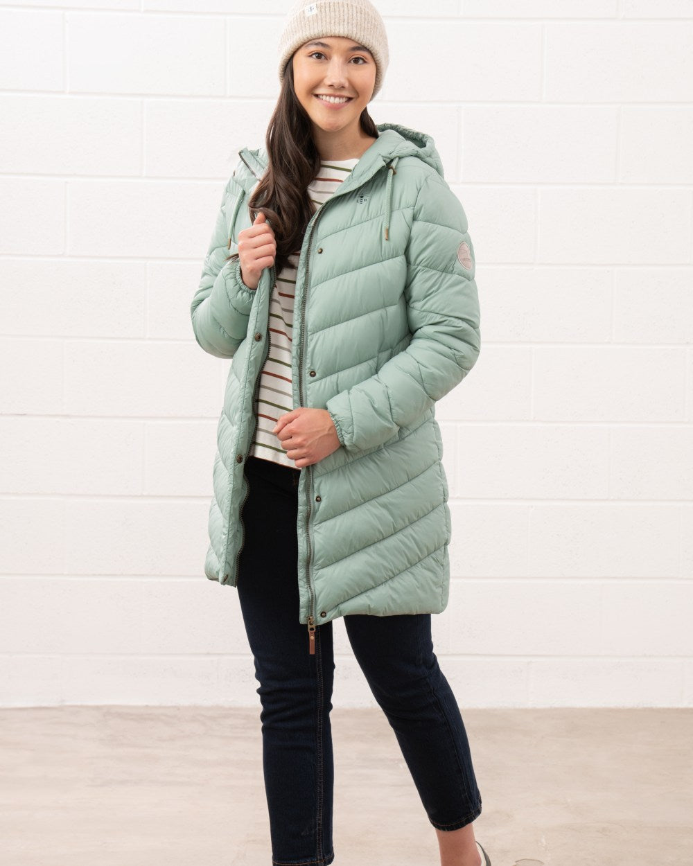 Sage coloured Lighthouse Laurel Ladies Coat on wall background