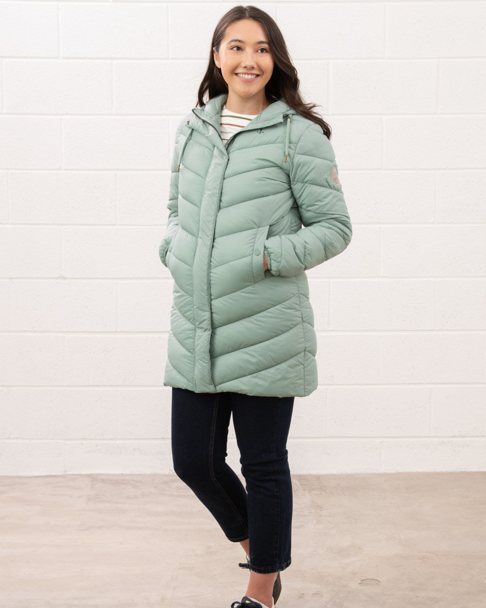 Sage coloured Lighthouse Laurel Ladies Coat on wall background