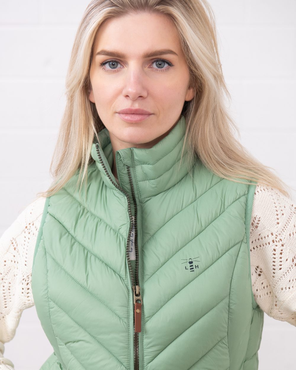Soft Sage coloured Lighthouse Laurel Ladies Gilet on wall background