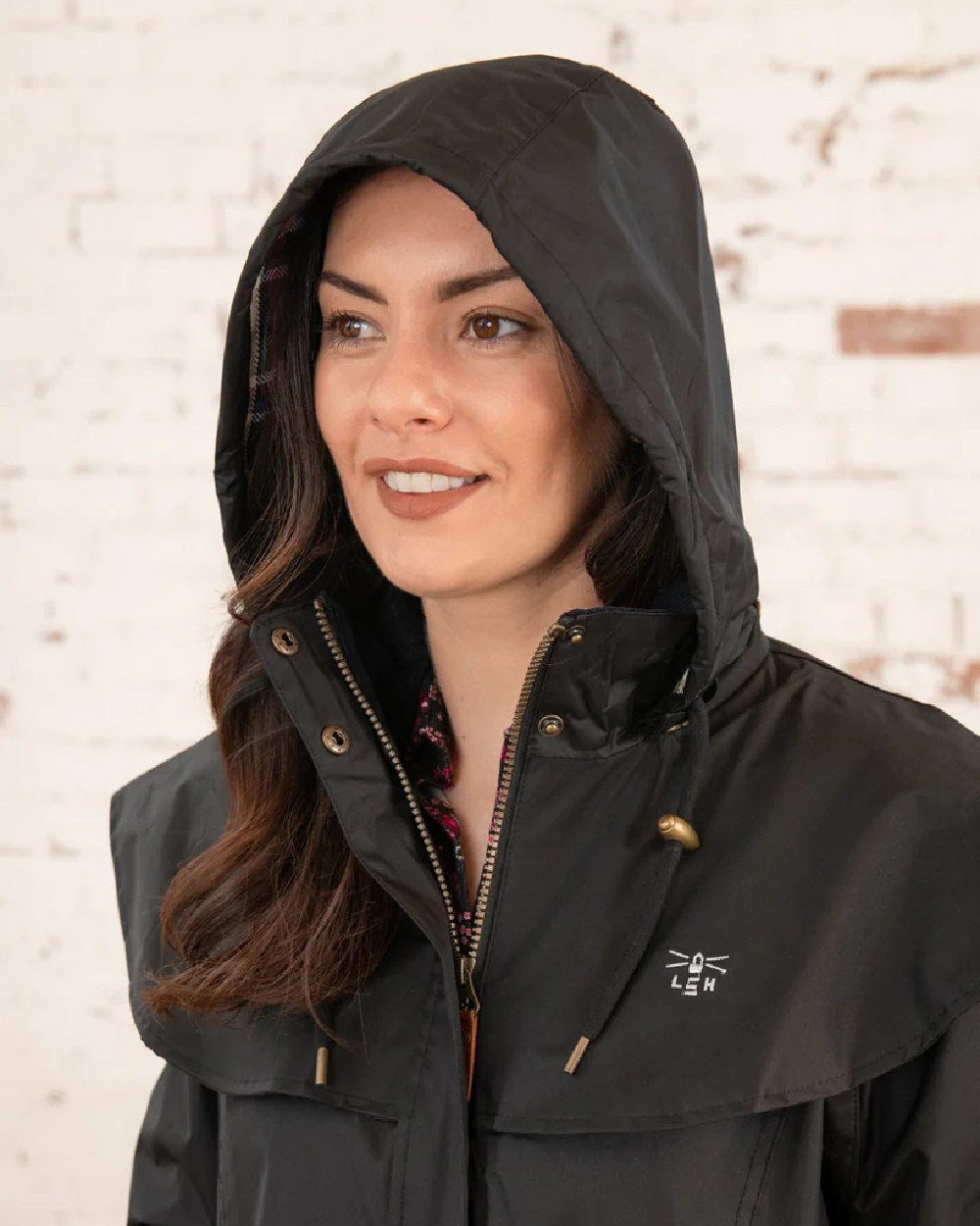 Black coloured Lighthouse Outback Full Length Ladies Waterproof Raincoat on wall background