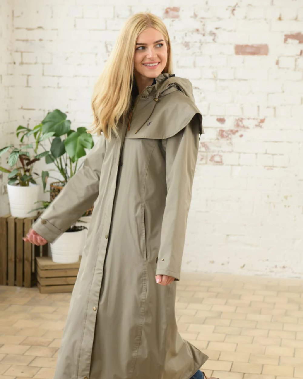 Fawn coloured Lighthouse Outback Full Length Ladies Waterproof Raincoat on wall background