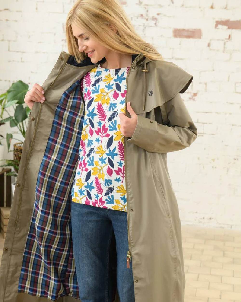 Fawn coloured Lighthouse Outback Full Length Ladies Waterproof Raincoat on wall background
