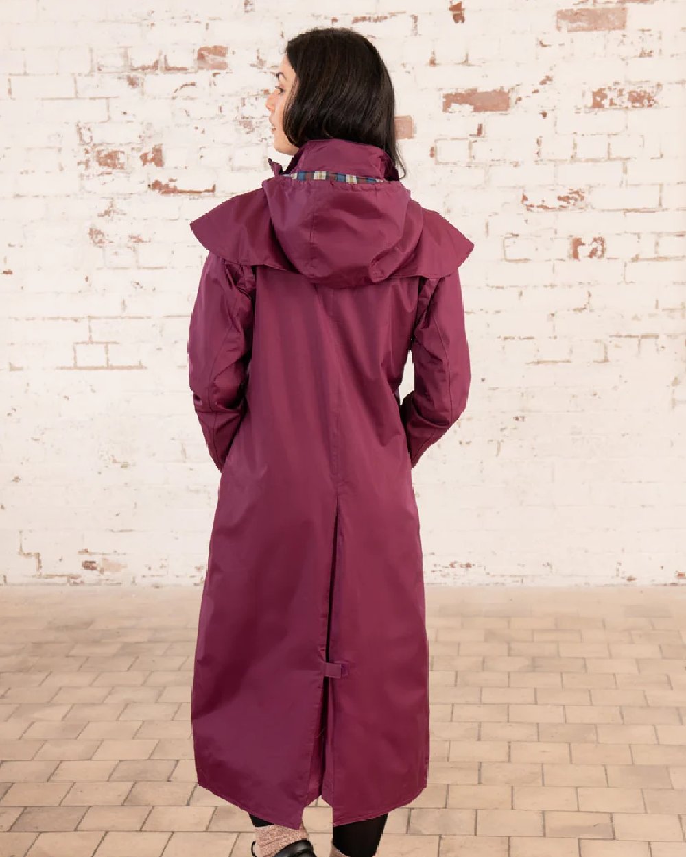 Plum coloured Lighthouse Outback Full Length Ladies Waterproof Raincoat on wall background