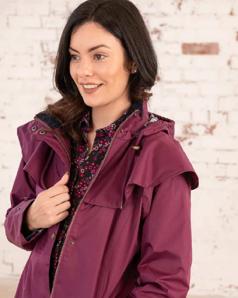 Plum coloured Lighthouse Outback Full Length Ladies Waterproof Raincoat on wall background
