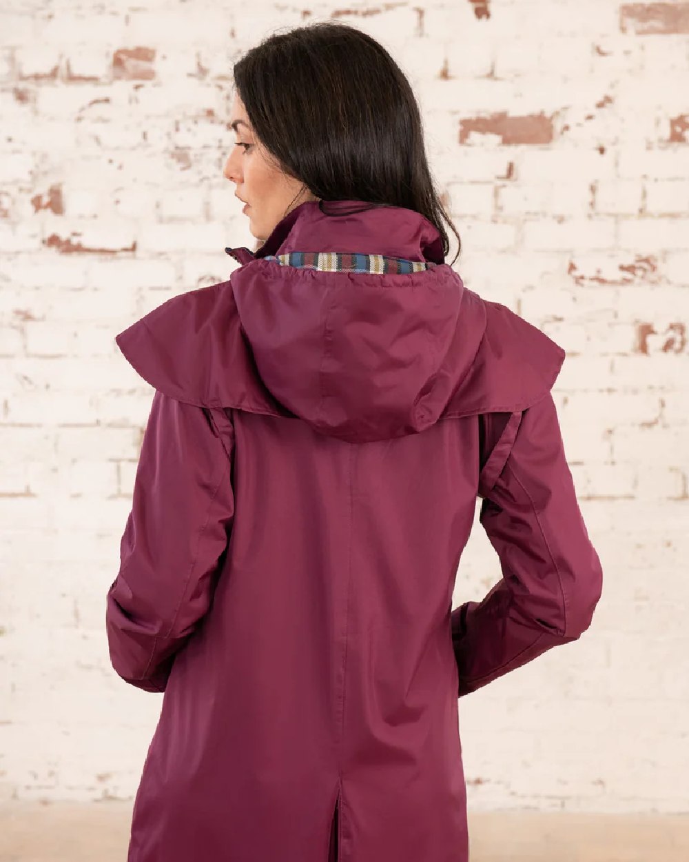 Plum coloured Lighthouse Outback Full Length Ladies Waterproof Raincoat on wall background