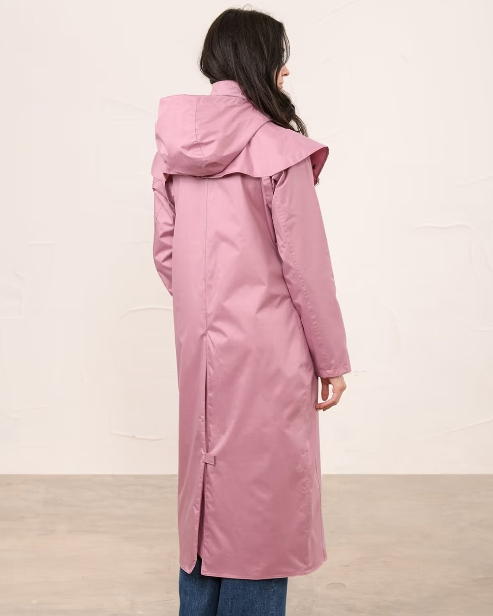 Wild Rose coloured Lighthouse Outback Full Length Ladies Waterproof Raincoat on wall background