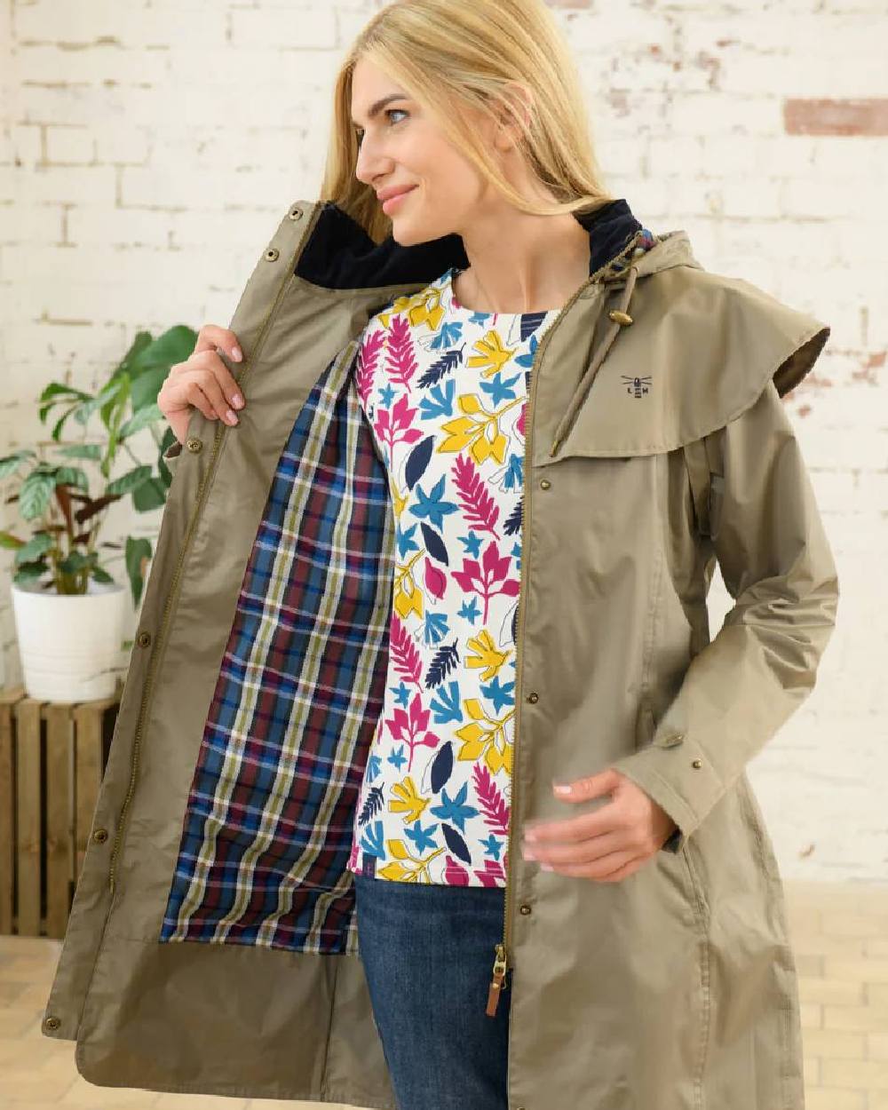 Fawn coloured Lighthouse Outrider 3/4 Length Ladies Waterproof Raincoat on wall background