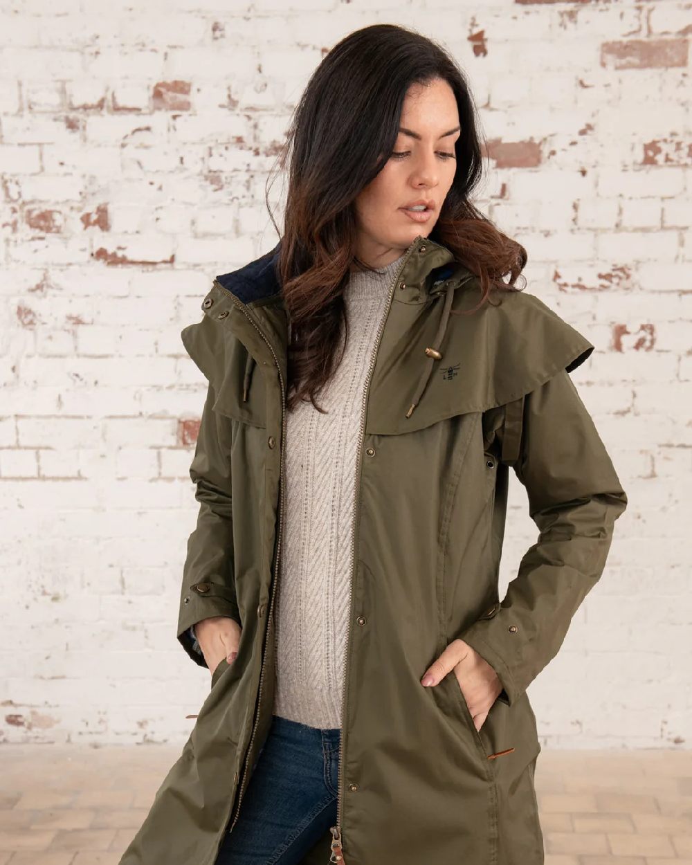 Fern coloured Lighthouse Outrider 3/4 Length Ladies Waterproof Raincoat on wall background