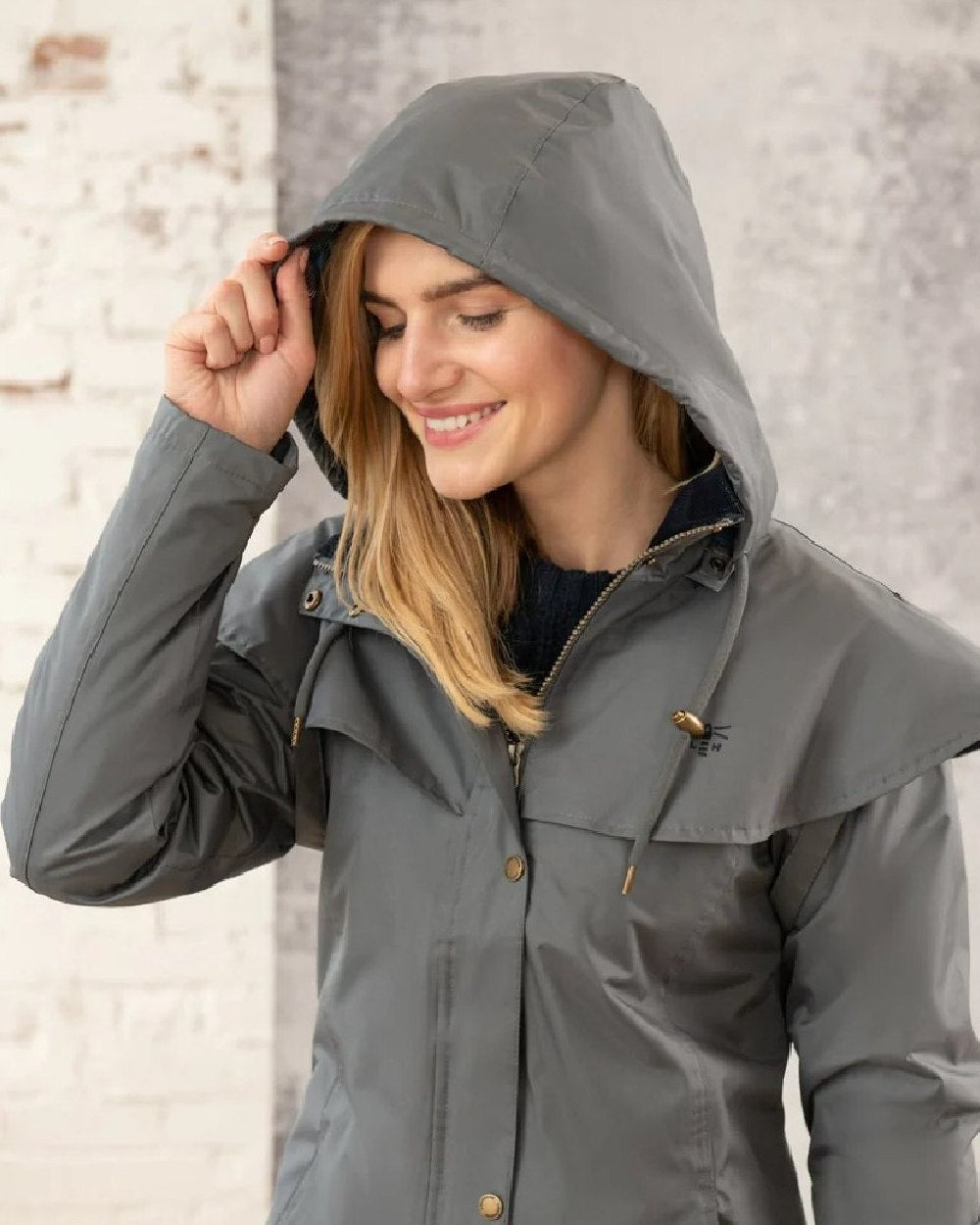 Urban Grey coloured Lighthouse Outrider 3/4 Length Ladies Waterproof Raincoat on wall background