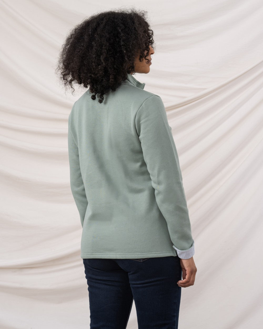 Sage coloured Lighthouse Shore Jersey Top on curtain background