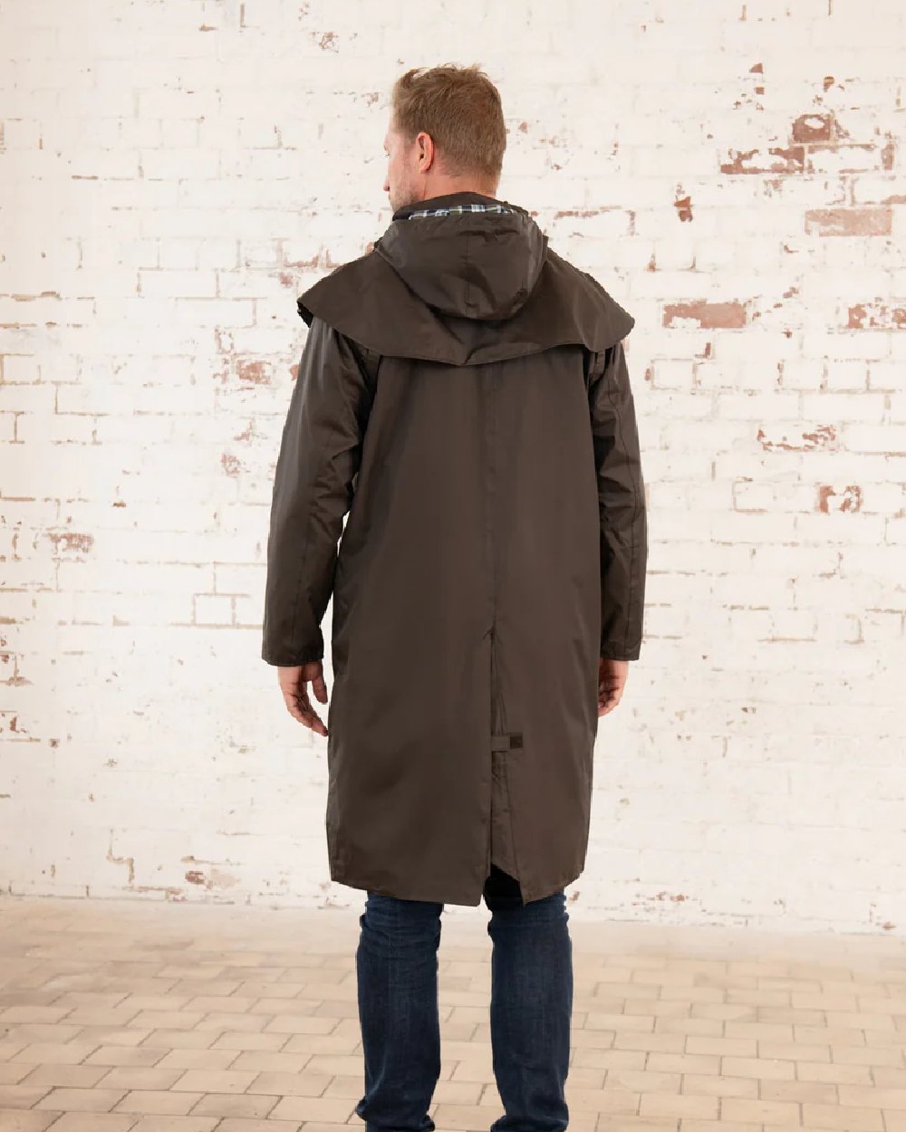 Chocolate coloured Lighthouse Stockman Long Waterproof Coat on wall background